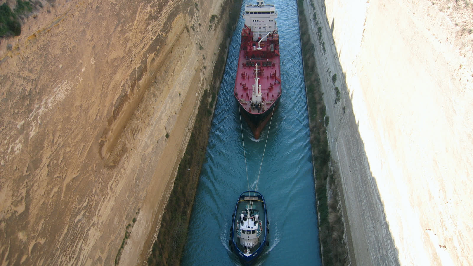 Two vessels passing between the sheer rock walls of the Corinth Canal, seen from above