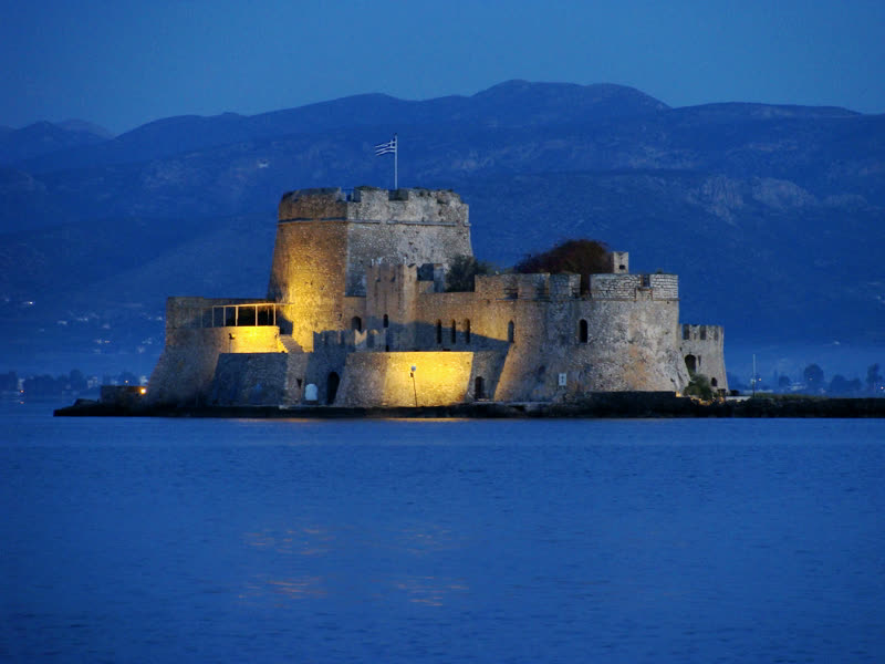 The Bourtzi fortress lit on the water at Nafplio in the blue hour