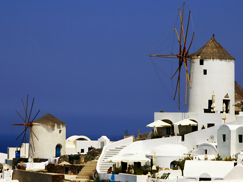 The windmills of Oia above the deep blue of the Aegean