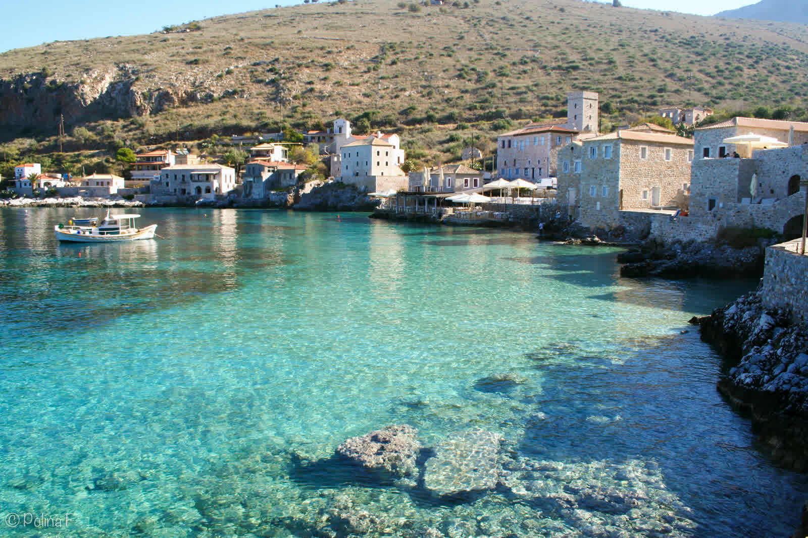 Stone houses of Limeni on the turquoise water of the Mani, below the bare mountain